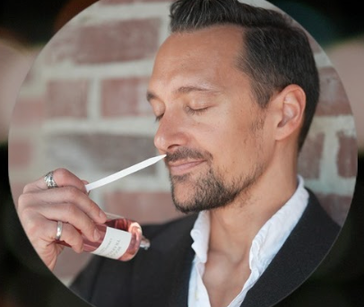 Close-up of a fragrance influencers with a collection of perfume bottles on their desk, enthusiastically discussing their favorite scents.